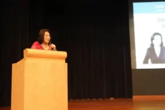 Dr Dora Hoan speaking on podium talking to DSAS meeting