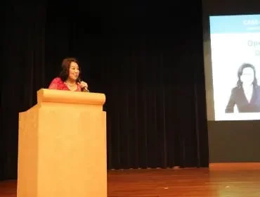 Dr Dora Hoan speaking on podium talking to DSAS meeting