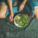 Top view of a person with a vegetarian bowl filled with ingredients that make up an Okinawan diet