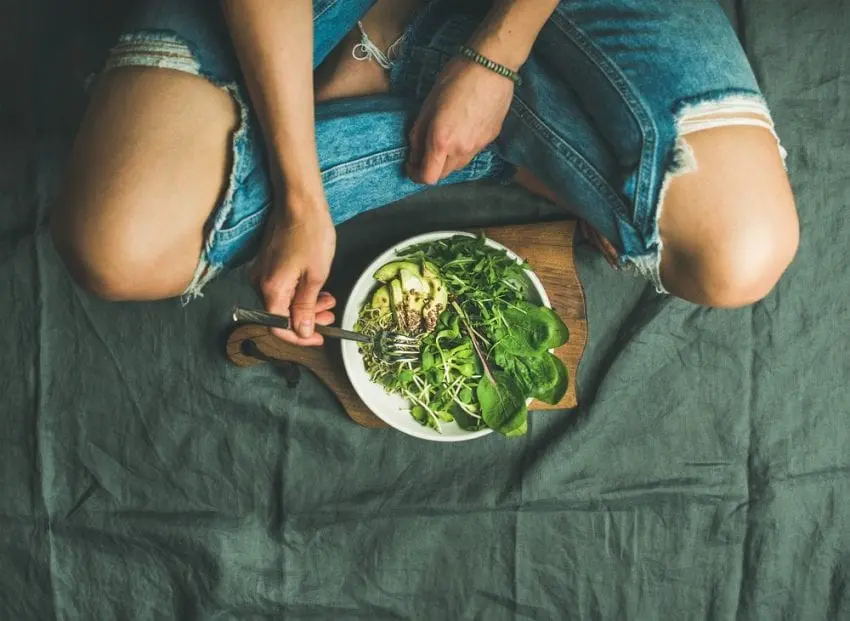 Top view of a person with a vegetarian bowl filled with ingredients that make up an Okinawan diet