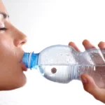 woman drinks from disposable bottle, unaware of concealed virus threat within.