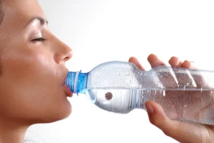 woman drinks from disposable bottle, unaware of concealed virus threat within.