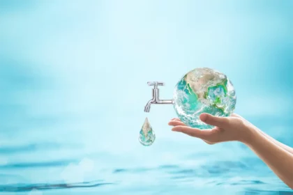A woman holding a globe with a faucet, promoting water conservation through awareness