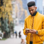 african-american-student-walking-street-talking-phone