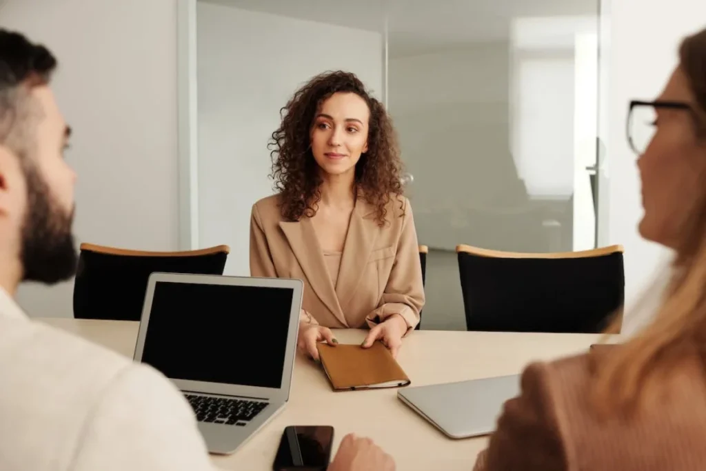 Man and woman interviewing another woman in office. 