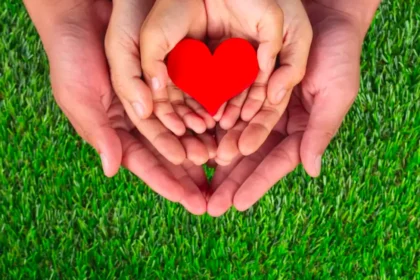 hands holding heart on a green background