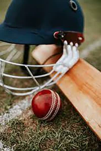 Cricket equipment on field with ball bat and helmet