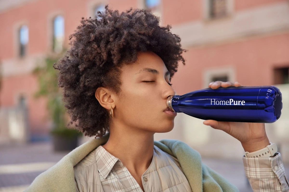 African woman hydrates using a HomePure bottle