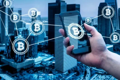 Bitcoin icons floating around man holding smart phone over city skyline