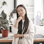 Woman sitting on office desk thinking