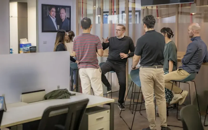 Trevor talking with QNET staff in office