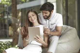 Couple looking at ipad smiling in modern home