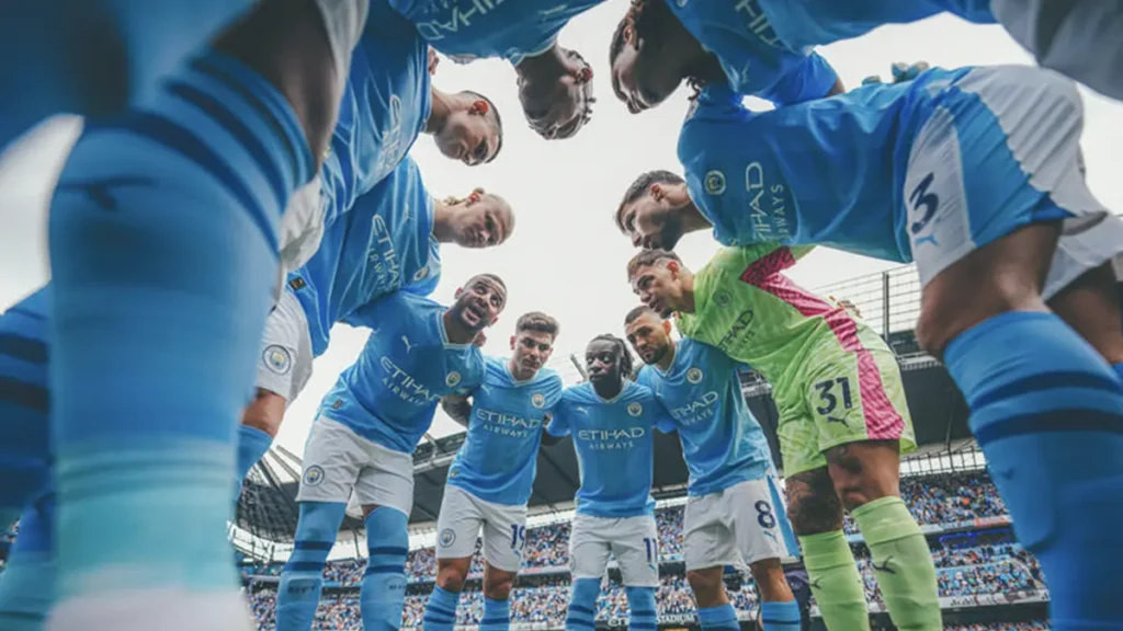 QNET-ManCity players, who have just been named Champions of the World 2023, huddle up before a game
