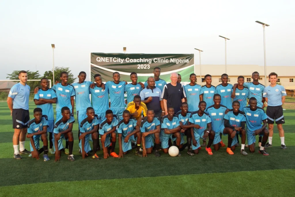 QNET city coaching clinic in nigeria posing on field 