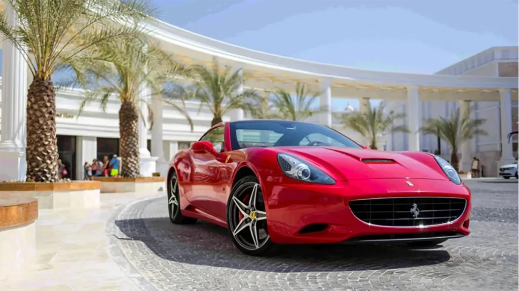 Ferrari car outside hotel building with palm trees