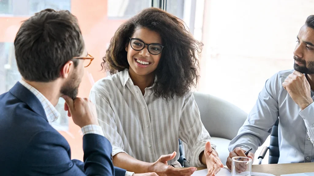 Woman in meeting room while two men listening to her