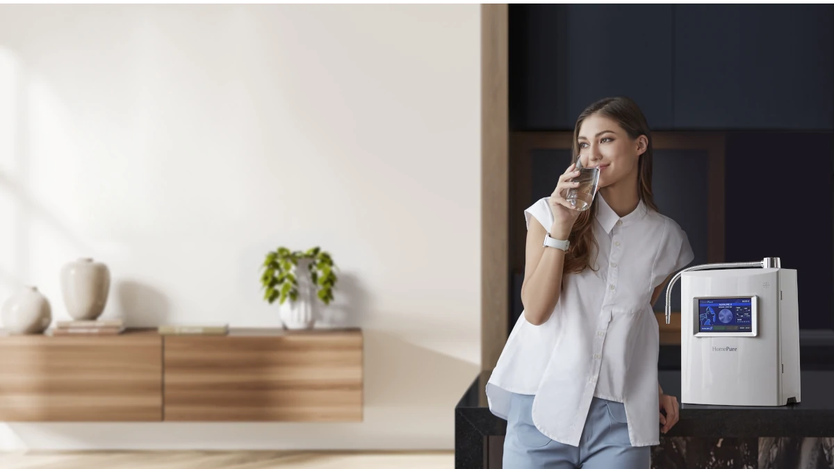 Woman standing next to homepure viva drinking water in kitchen
