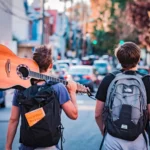 Two boys, one holding a guitar, on their way to enjoy the long weekend with a quick vacation via QVI Breaks