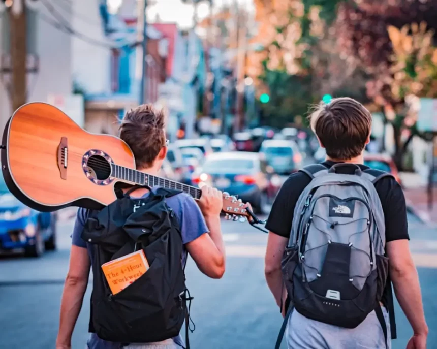 Two boys, one holding a guitar, on their way to enjoy the long weekend with a quick vacation via QVI Breaks