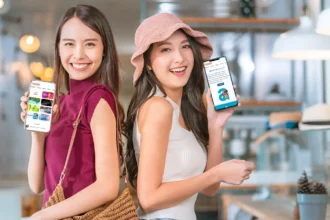 2 women smiling showing qbuzz on their mobile phones