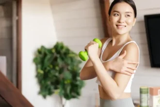 Woman exercising with a small dumbbell, reaping the benefits of a plant-based diet, which helps address climate change