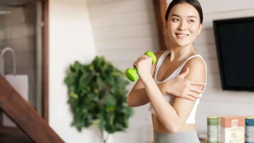 Woman exercising with a small dumbbell, reaping the benefits of a plant-based diet, which helps address climate change
