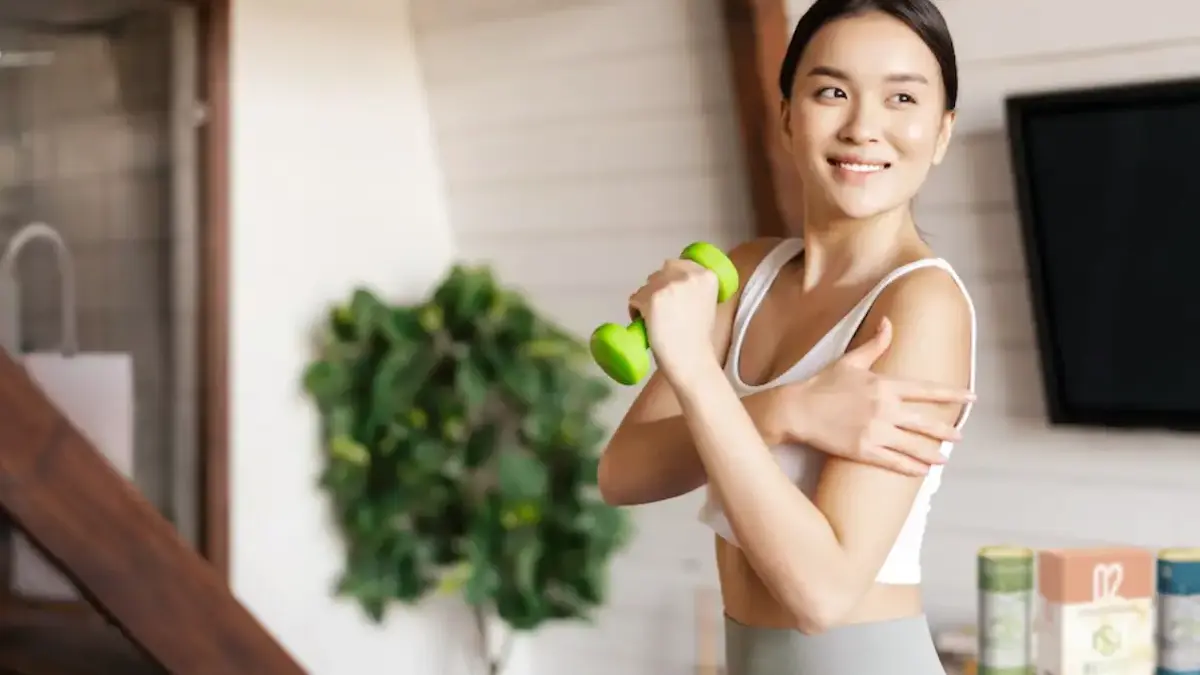 Woman exercising with a small dumbbell, reaping the benefits of a plant-based diet, which helps address climate change