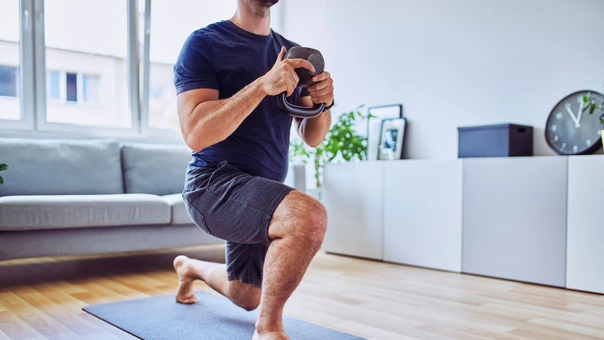 Guy working out with a kettlebell as part of his fitness resolutions to develop the healthy habits of successful people