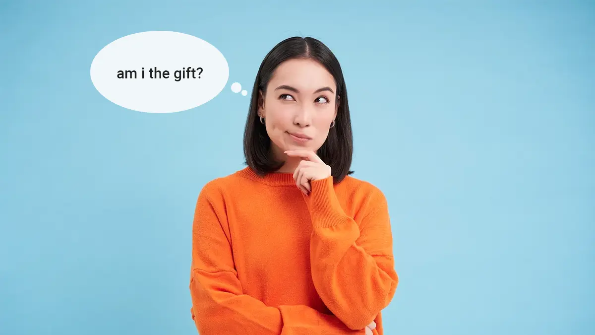 Woman in orange sweater thinking - Am I The Gift? 