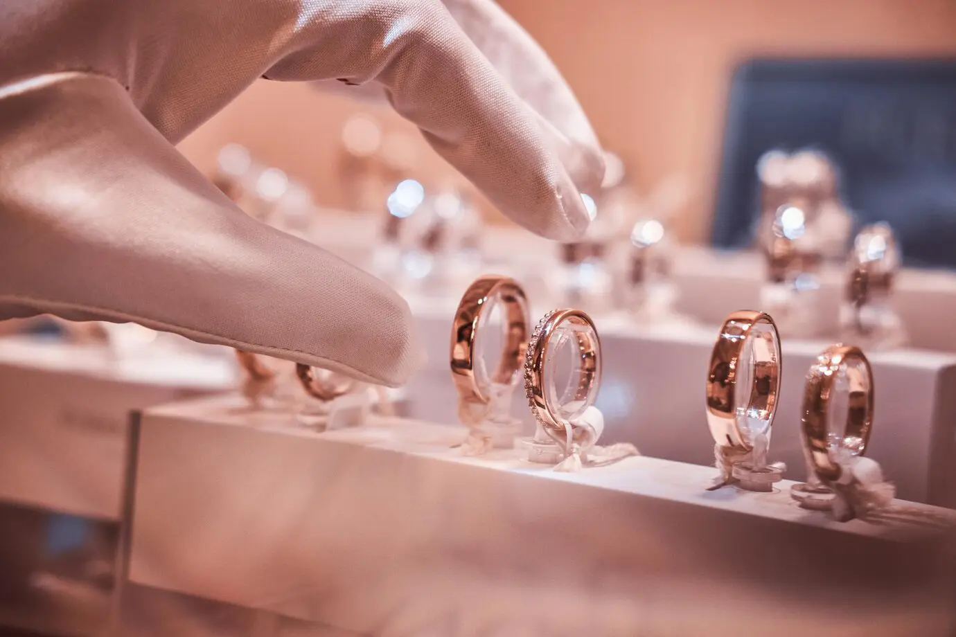 18k gold jewellery showcased in a luxury store, displayed on hand gloves