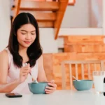 Girl having breakfast with Ole Olive Leaf Extract on the table