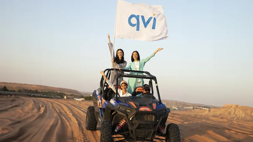Girls on a jeep with a QVI flag, riding in the desert where they enjoyed stress-free travel to for their holiday